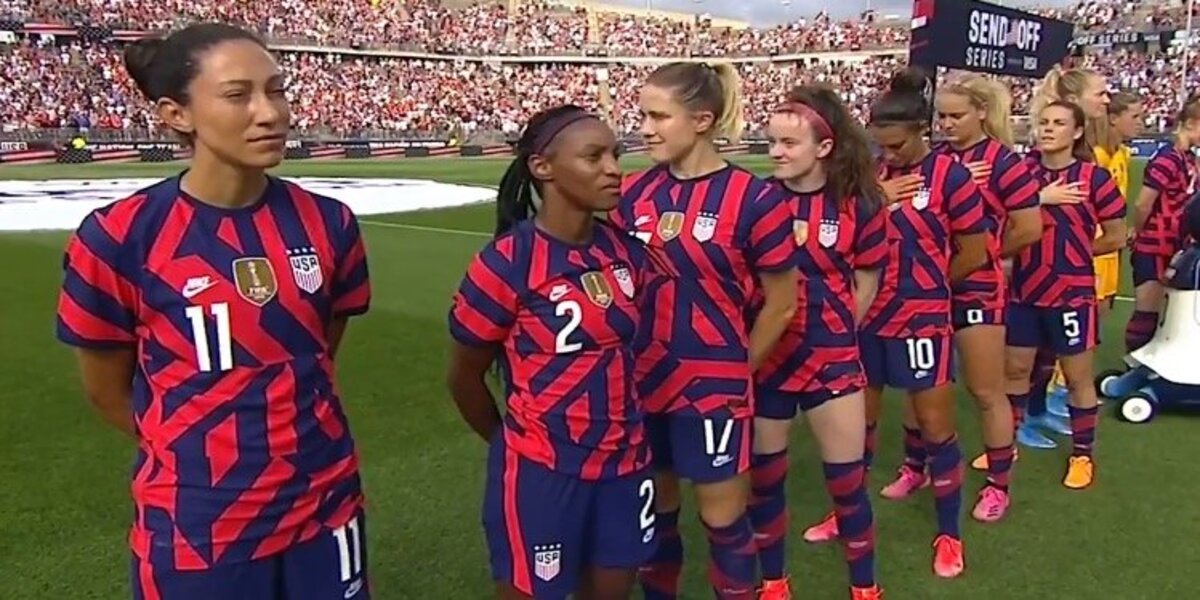 U.S. soccer players walk away from national anthem being played by World War II veteran