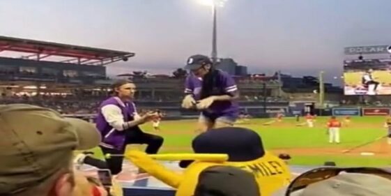 A woman runs away from her partner's marriage proposal at a baseball stadium